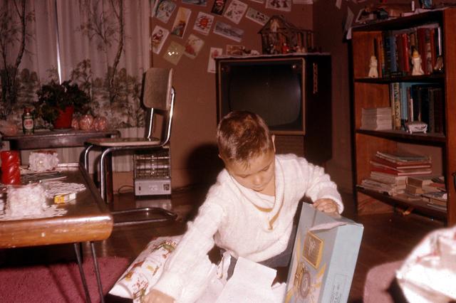 1960, 12: Steve opening gifts