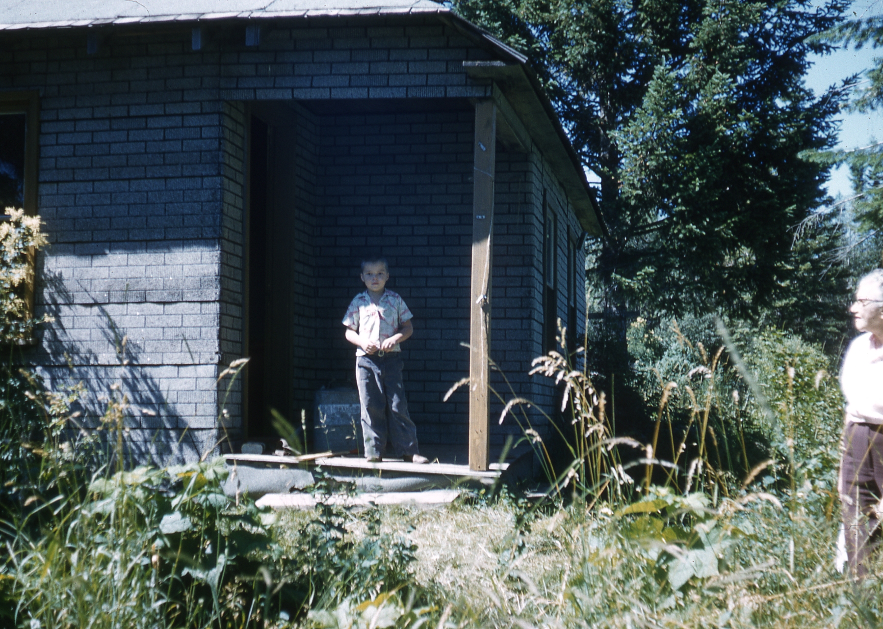 1958, 07: boy at cabin?