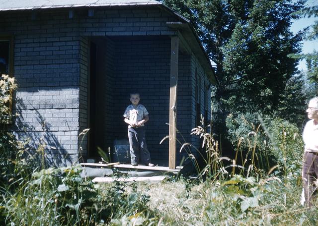 1958, 07: boy at cabin?