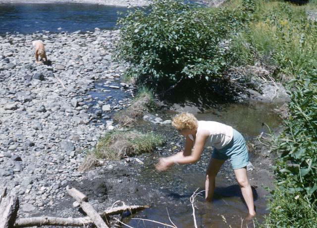 1960, 08: Woman on bank of river or lake?